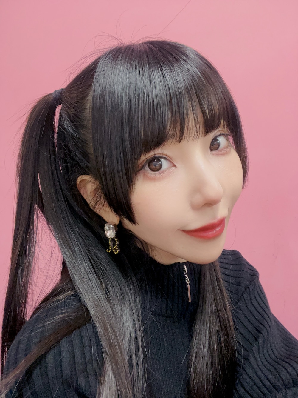 グレー系のスカート、ブラック系のアンサンブル、ブラック系のブーツを着用したレディースの春コーディネートの2枚目の写真