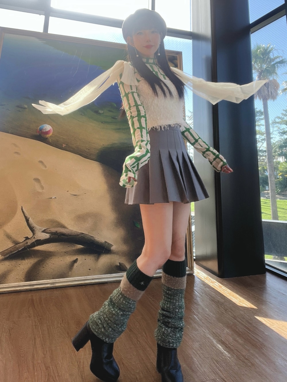 グレー系のスカート、ホワイト系のその他トップス、グリーン系のTシャツ/カットソーを着用したレディースの冬コーディネートの2枚目の写真