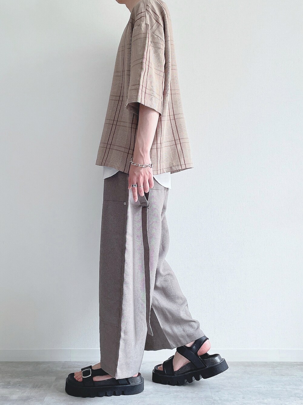 ブラウン系のTシャツ/カットソー、ホワイト系のタンクトップ、ベージュ系のスラックスを着用したメンズの夏コーディネートの3枚目の写真