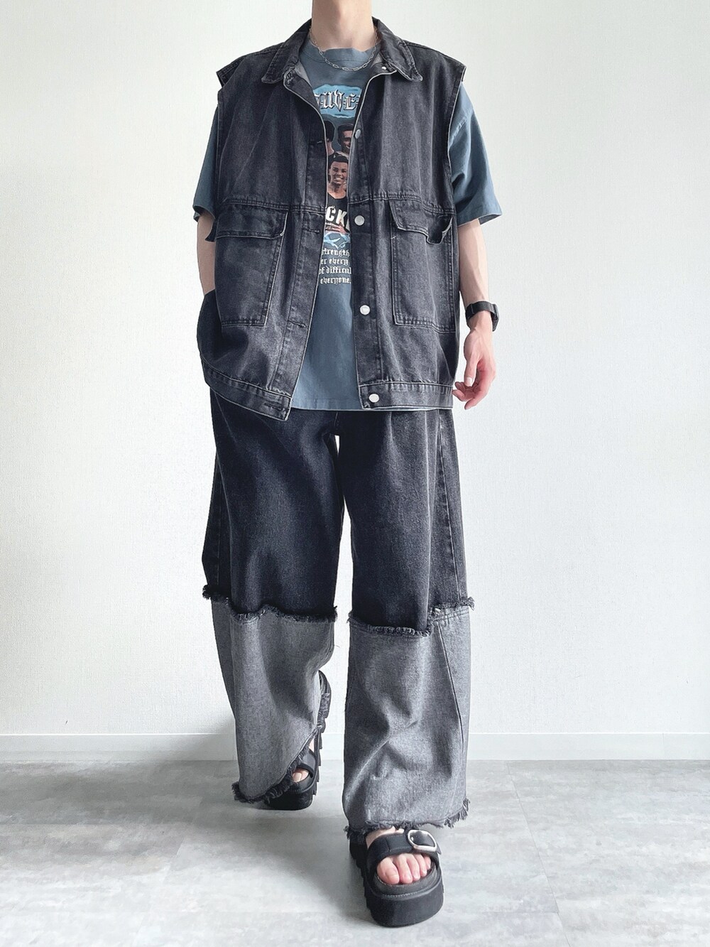 ブラック系のベスト、ブルー系のTシャツ/カットソー、ブラック系のデニムパンツを着用したメンズの夏コーディネートの2枚目の写真