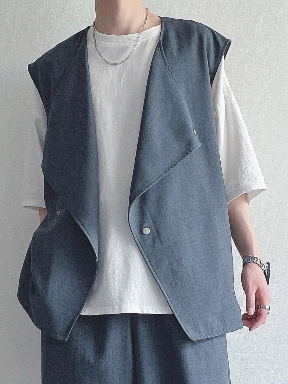 ブルー系のベスト、ホワイト系のTシャツ/カットソー、ブルー系のスラックスを着用したメンズの春コーディネートの3枚目の写真