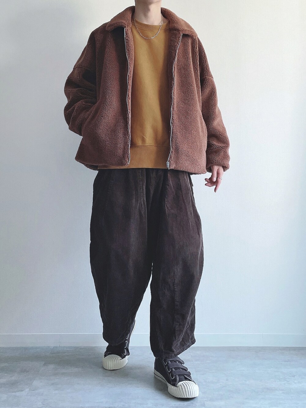 ブラウン系のジャケット/アウター、イエロー系のトップス、ブラウン系のその他パンツを着用したメンズの冬コーディネートの4枚目の写真