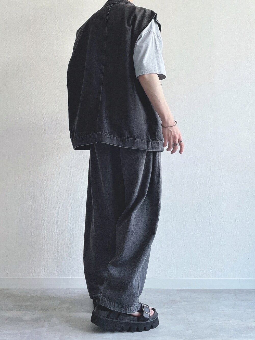 ブラック系のベスト、ブルー系のTシャツ/カットソー、ブラック系のデニムパンツを着用したメンズの夏コーディネートの4枚目の写真