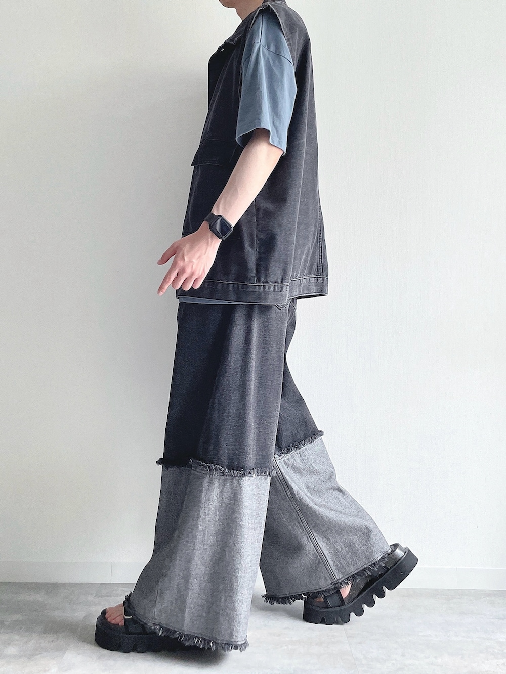 ブラック系のベスト、ブルー系のTシャツ/カットソー、ブラック系のデニムパンツを着用したメンズの夏コーディネートの3枚目の写真