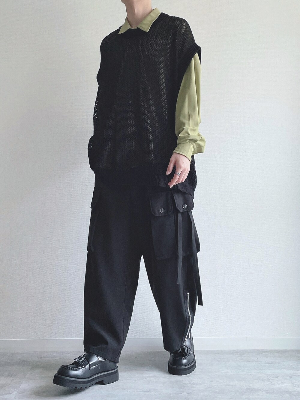 グリーン系のシャツ/ブラウス、ブラック系のベスト、ブラック系のカーゴパンツを着用したメンズの春コーディネートの5枚目の写真