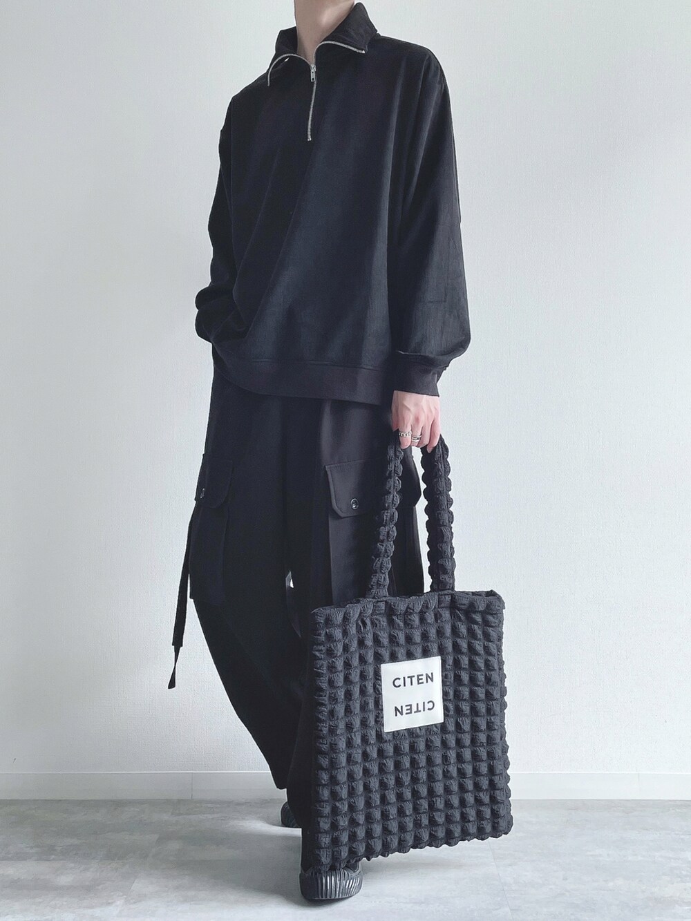 ブラック系のスウェット、ブラック系のカーゴパンツ、ブラック系のスニーカーを着用したメンズの冬コーディネートの5枚目の写真