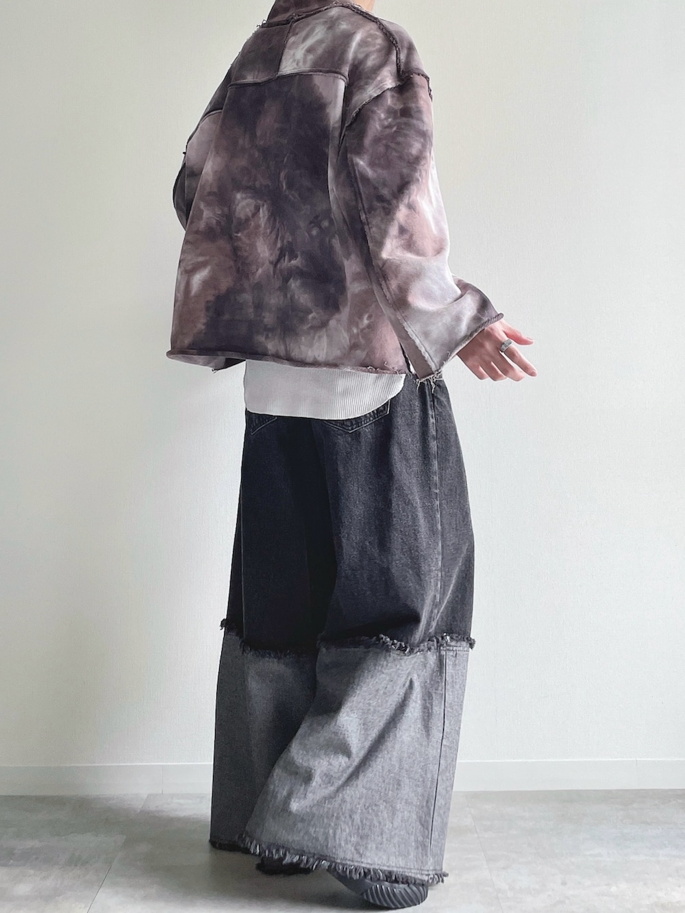 ブラウン系のスウェット、ホワイト系のタンクトップ、ブラック系のデニムパンツを着用したメンズの春コーディネートの3枚目の写真