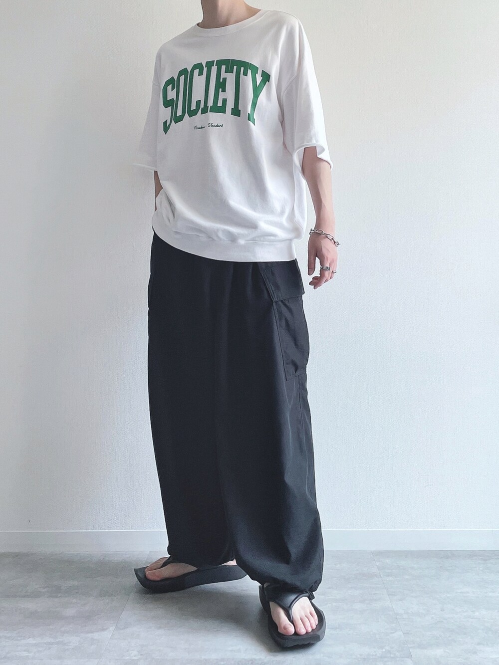 ホワイト系のTシャツ/カットソー、ブラック系のその他パンツ、ブラック系のサンダルを着用したメンズの夏コーディネートの4枚目の写真