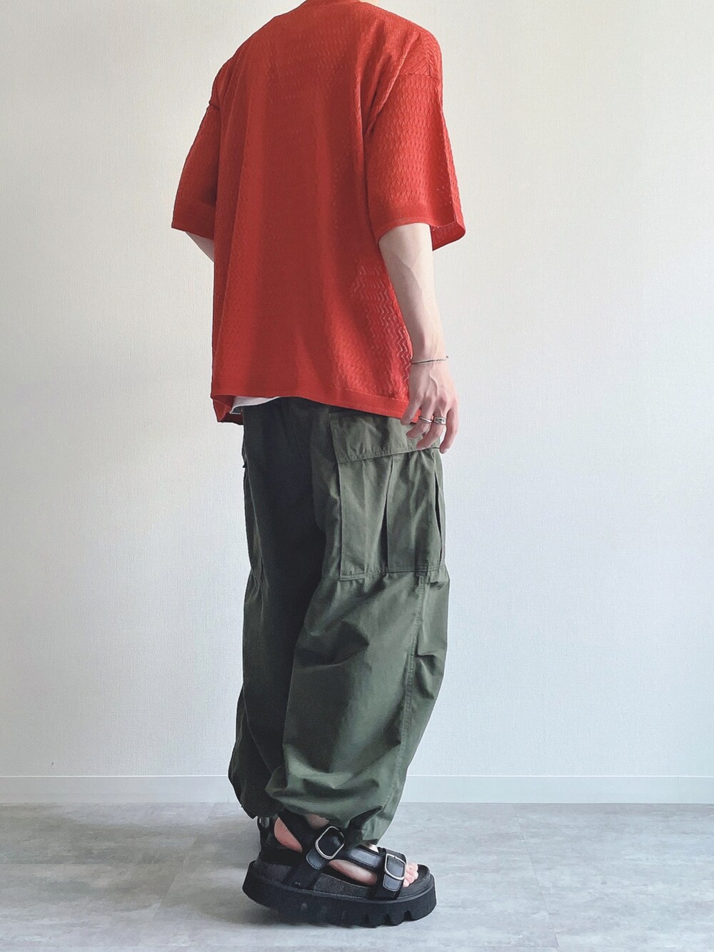 オレンジ系のシャツ/ブラウス、ホワイト系のTシャツ/カットソー、グリーン系のカーゴパンツを着用したメンズの夏コーディネートの3枚目の写真