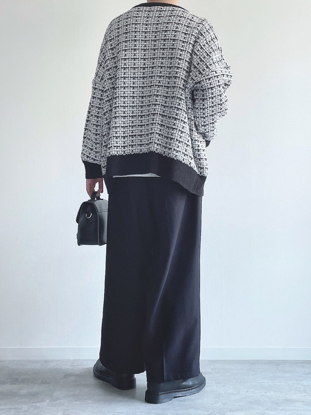 ブラック系のカーディガン/ボレロ、ホワイト系のTシャツ/カットソー、ブラック系のスラックスを着用したメンズの春コーディネートの3枚目の写真