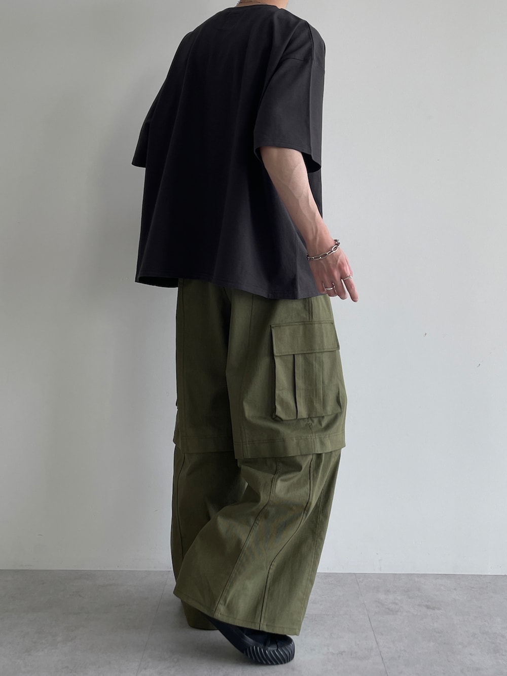 グリーン系のカーゴパンツ、ブラック系のスニーカー、グレー系のTシャツ/カットソーを着用したメンズの夏コーディネートの4枚目の写真