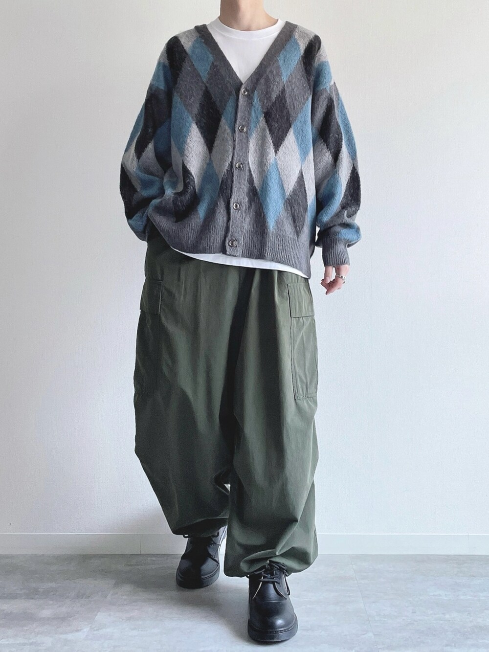 グレー系のカーディガン/ボレロ、ホワイト系のTシャツ/カットソー、グリーン系のカーゴパンツを着用したメンズの冬コーディネートの2枚目の写真