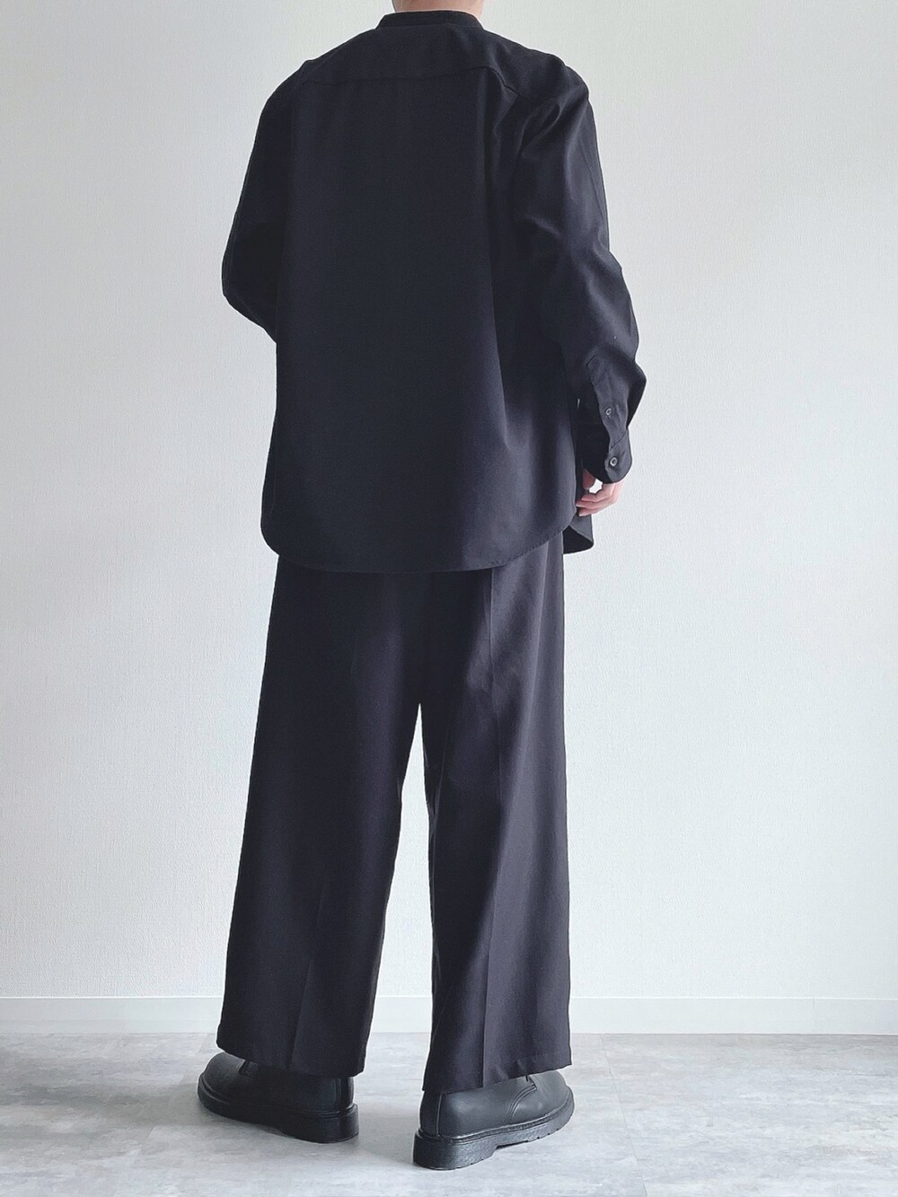 ブラック系のトップス、ホワイト系のTシャツ/カットソー、ブラック系のスラックスを着用したメンズの春コーディネートの4枚目の写真