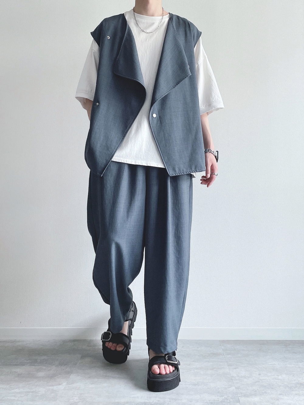 ブルー系のベスト、ホワイト系のTシャツ/カットソー、ブルー系のスラックスを着用したメンズの春コーディネートの2枚目の写真