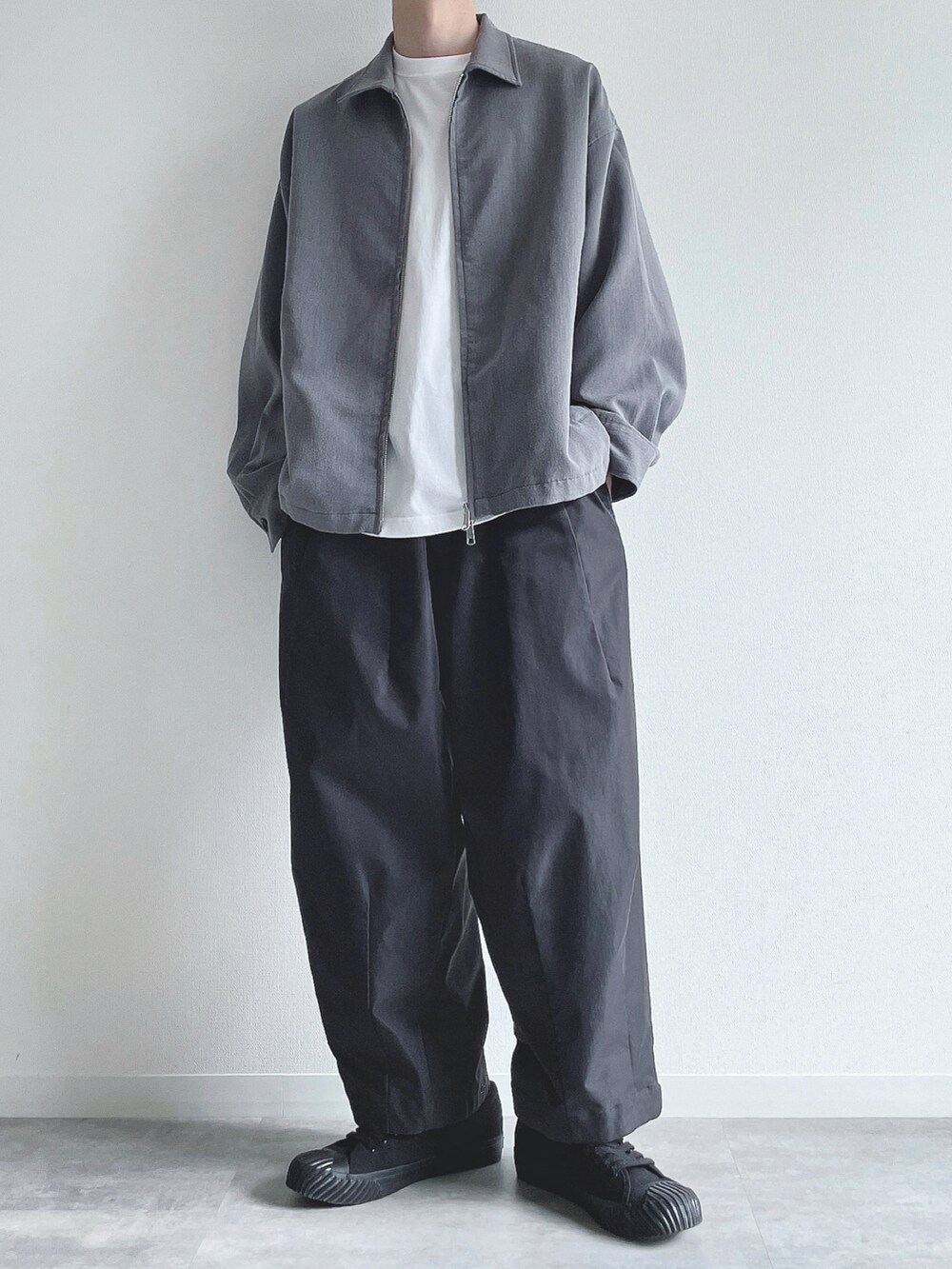 グレー系のブルゾン、ホワイト系のTシャツ/カットソー、ブラック系のその他パンツを着用したメンズの秋コーディネートの2枚目の写真