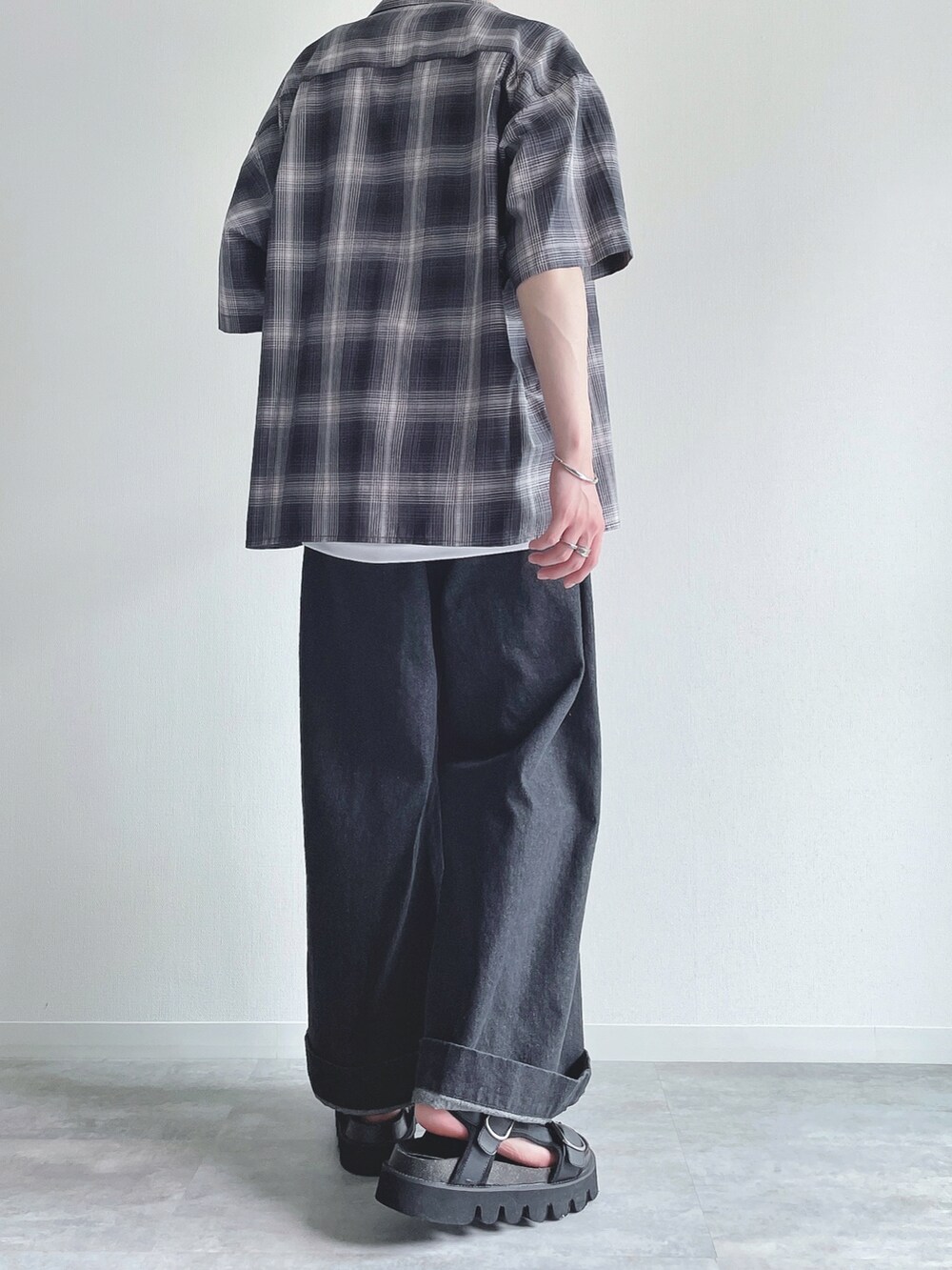 ブラック系のシャツ/ブラウス、ホワイト系のタンクトップ、ブラック系のデニムパンツを着用したメンズの夏コーディネートの4枚目の写真