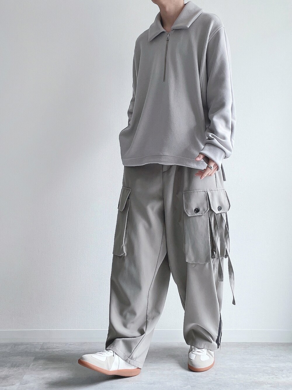 グレー系のカーゴパンツ、ホワイト系のスニーカー、シルバー系のブレスレットを着用したメンズの春コーディネートの5枚目の写真
