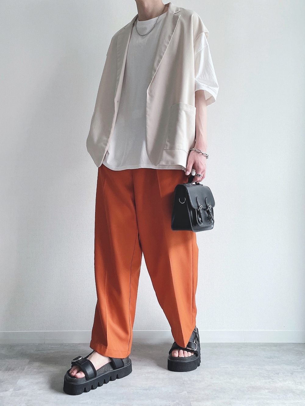 ホワイト系のベスト、ホワイト系のTシャツ/カットソー、オレンジ系のスラックスを着用したメンズの夏コーディネートの5枚目の写真