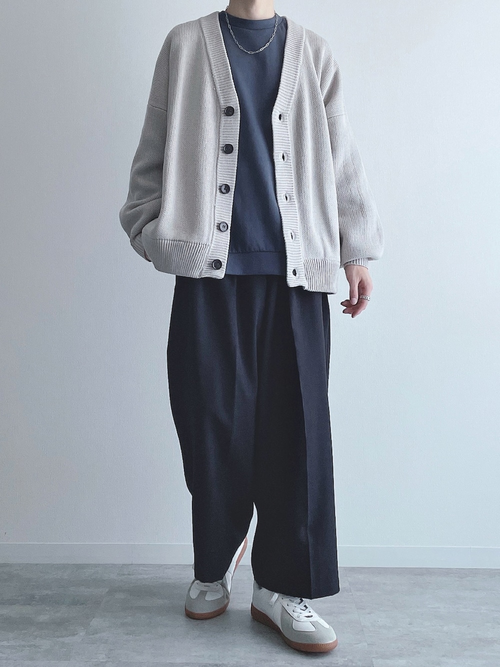 グレー系のカーディガン/ボレロ、ブルー系のトップス、ブラック系のスラックスを着用したメンズの秋コーディネートの5枚目の写真