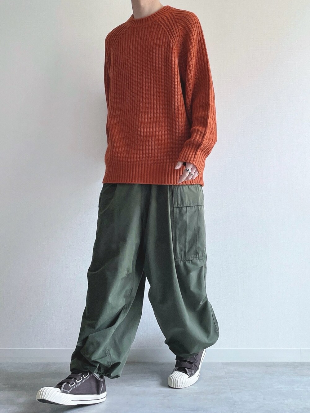 オレンジ系のトップス、グリーン系のカーゴパンツ、ブラウン系のスニーカーを着用したメンズの冬コーディネートの5枚目の写真