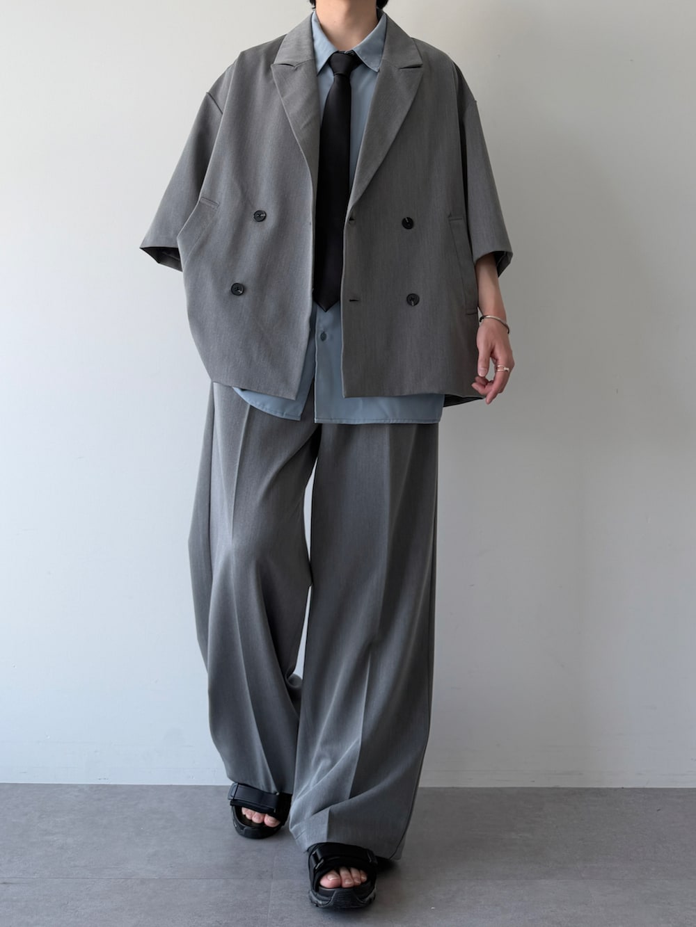 ブルー系のシャツ/ブラウス、グレー系のセットアップ、ブラック系のシューズを着用したメンズの夏コーディネートの2枚目の写真