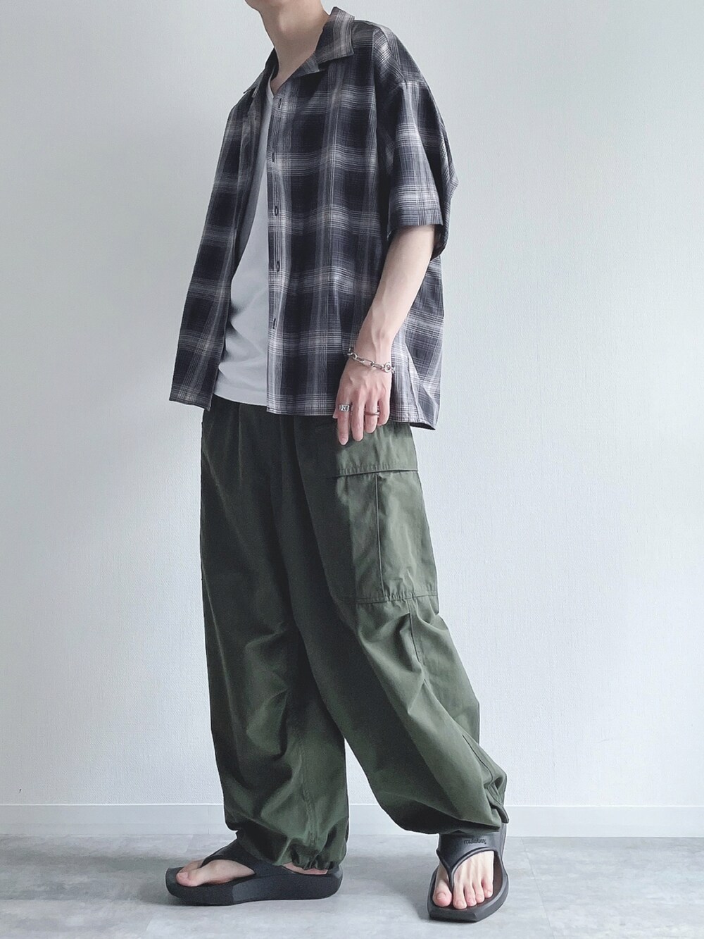 ブラック系のシャツ/ブラウス、ホワイト系のタンクトップ、グリーン系のカーゴパンツを着用したメンズの夏コーディネートの3枚目の写真