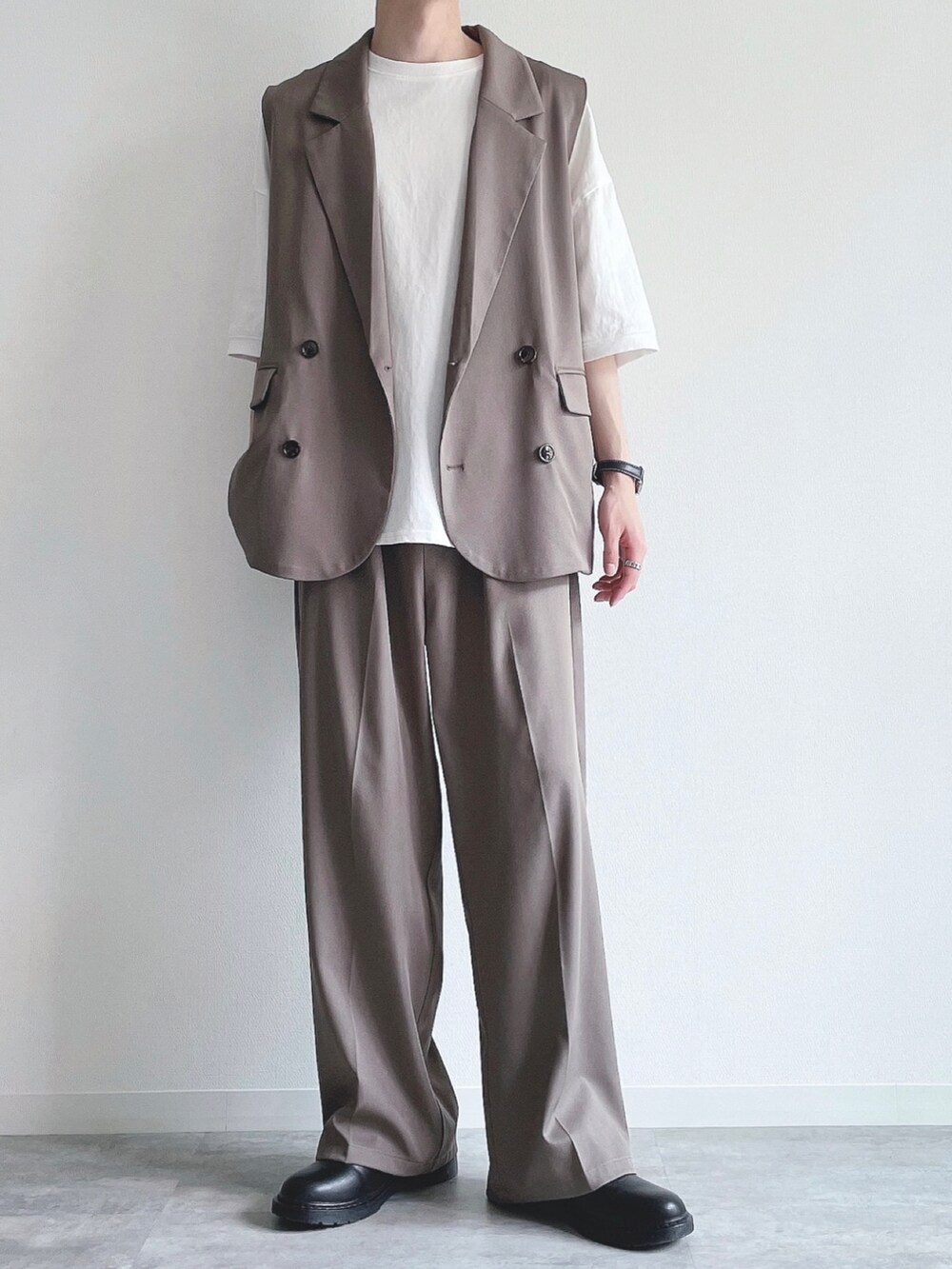 ベージュ系のベスト、ホワイト系のTシャツ/カットソー、ベージュ系のスラックスを着用したメンズの夏コーディネートの2枚目の写真