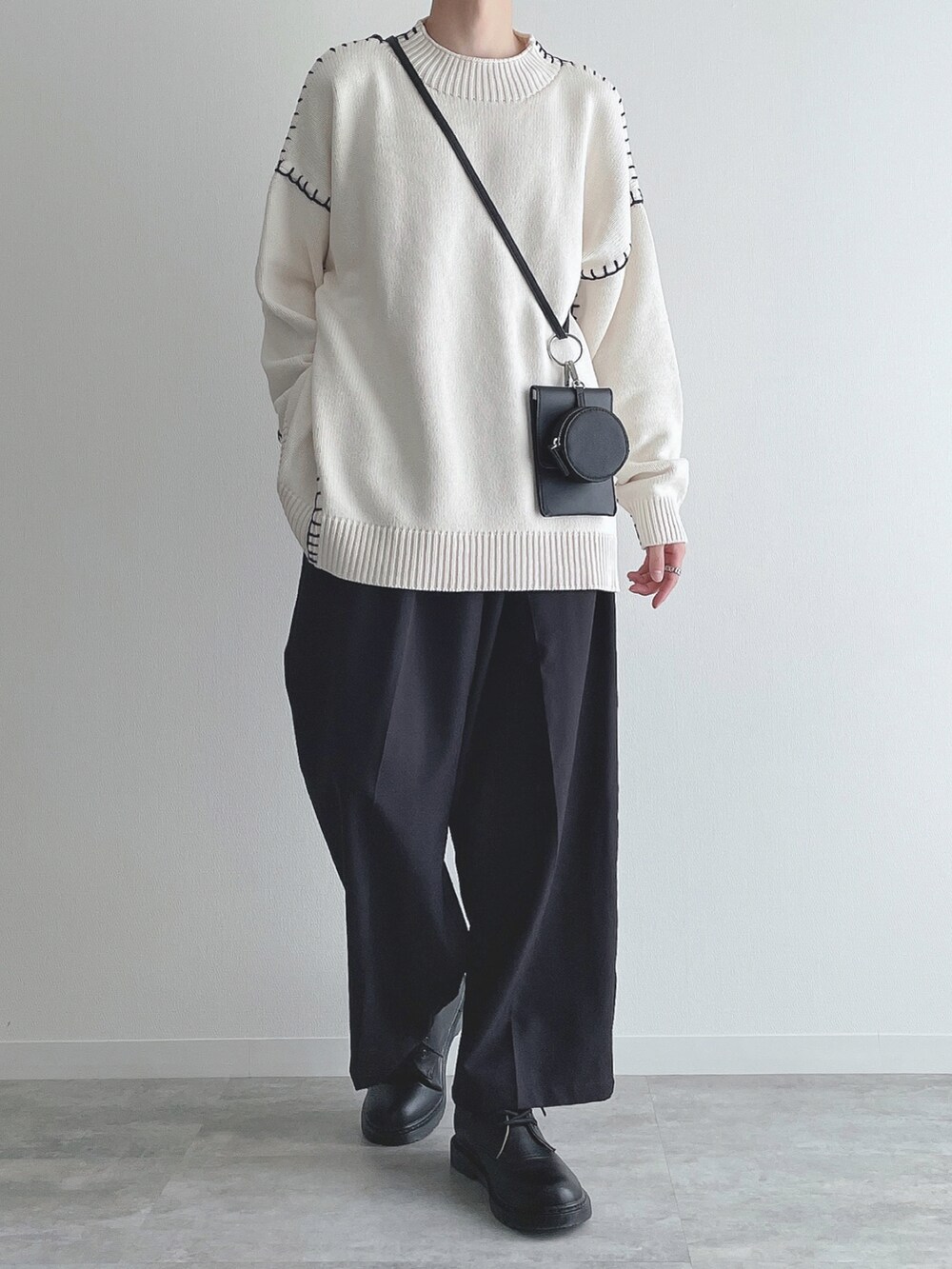 ホワイト系のニット/セーター、ブラック系のスラックス、ブラック系のドレスシューズを着用したメンズの秋コーディネートの3枚目の写真