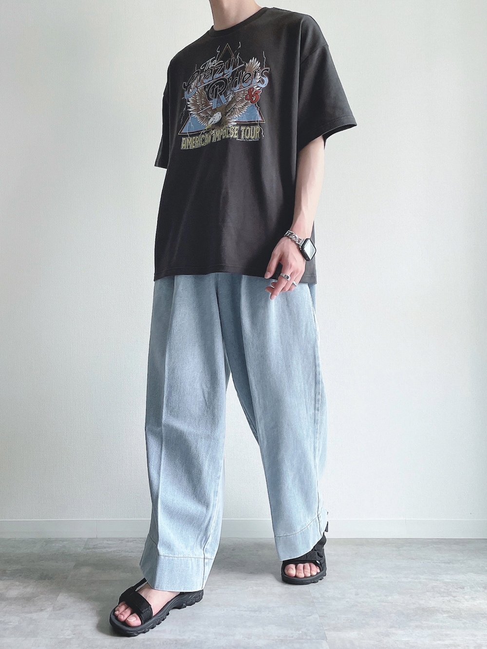 ブラック系のTシャツ/カットソー、ブルー系のデニムパンツ、ブラック系のサンダルを着用したメンズの夏コーディネートの5枚目の写真