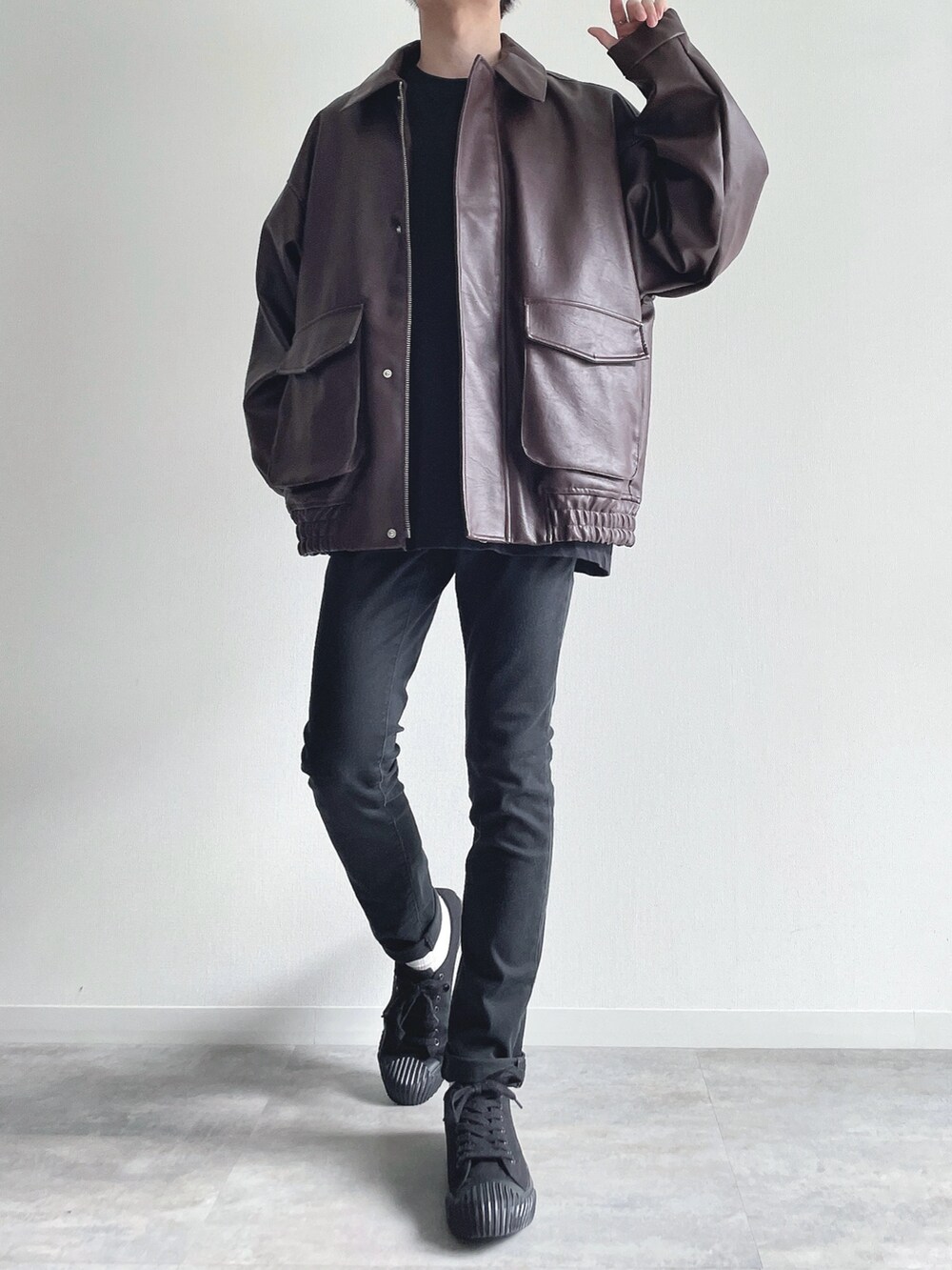 ブラウン系のブルゾン、ブラック系のTシャツ/カットソー、ブラック系のパンツを着用したメンズの冬コーディネートの2枚目の写真