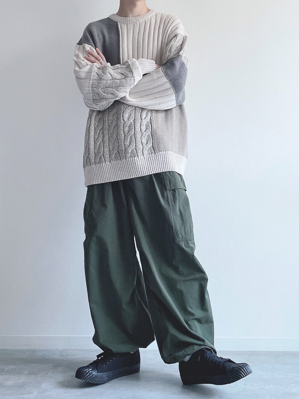 ホワイト系のニット/セーター、グリーン系のカーゴパンツ、ブラック系のスニーカーを着用したメンズの冬コーディネートの5枚目の写真