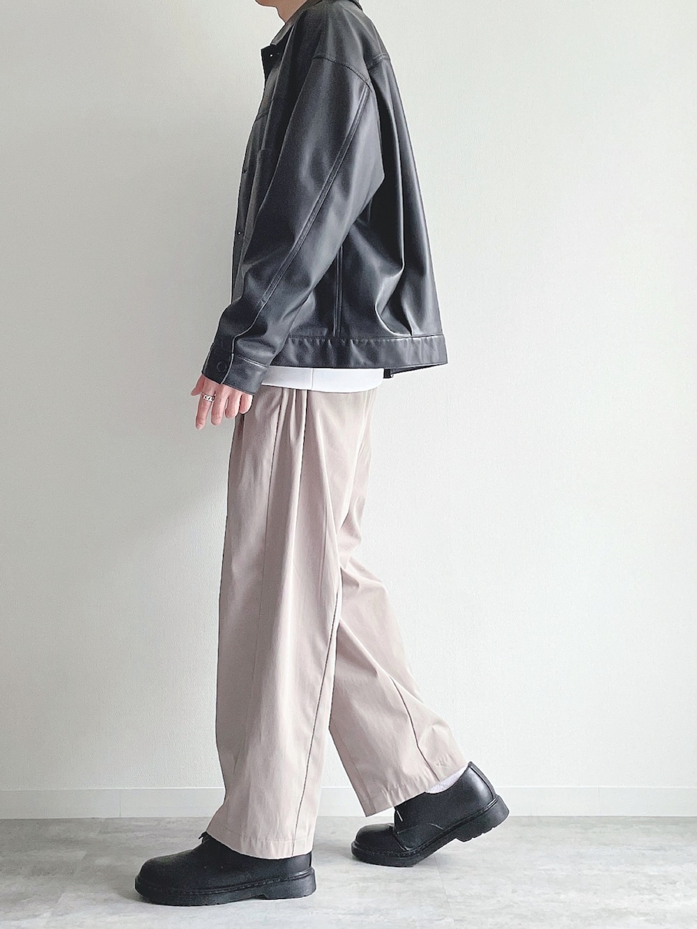 ブラック系のブルゾン、ホワイト系のトップス、ベージュ系のその他パンツを着用したメンズの冬コーディネートの3枚目の写真