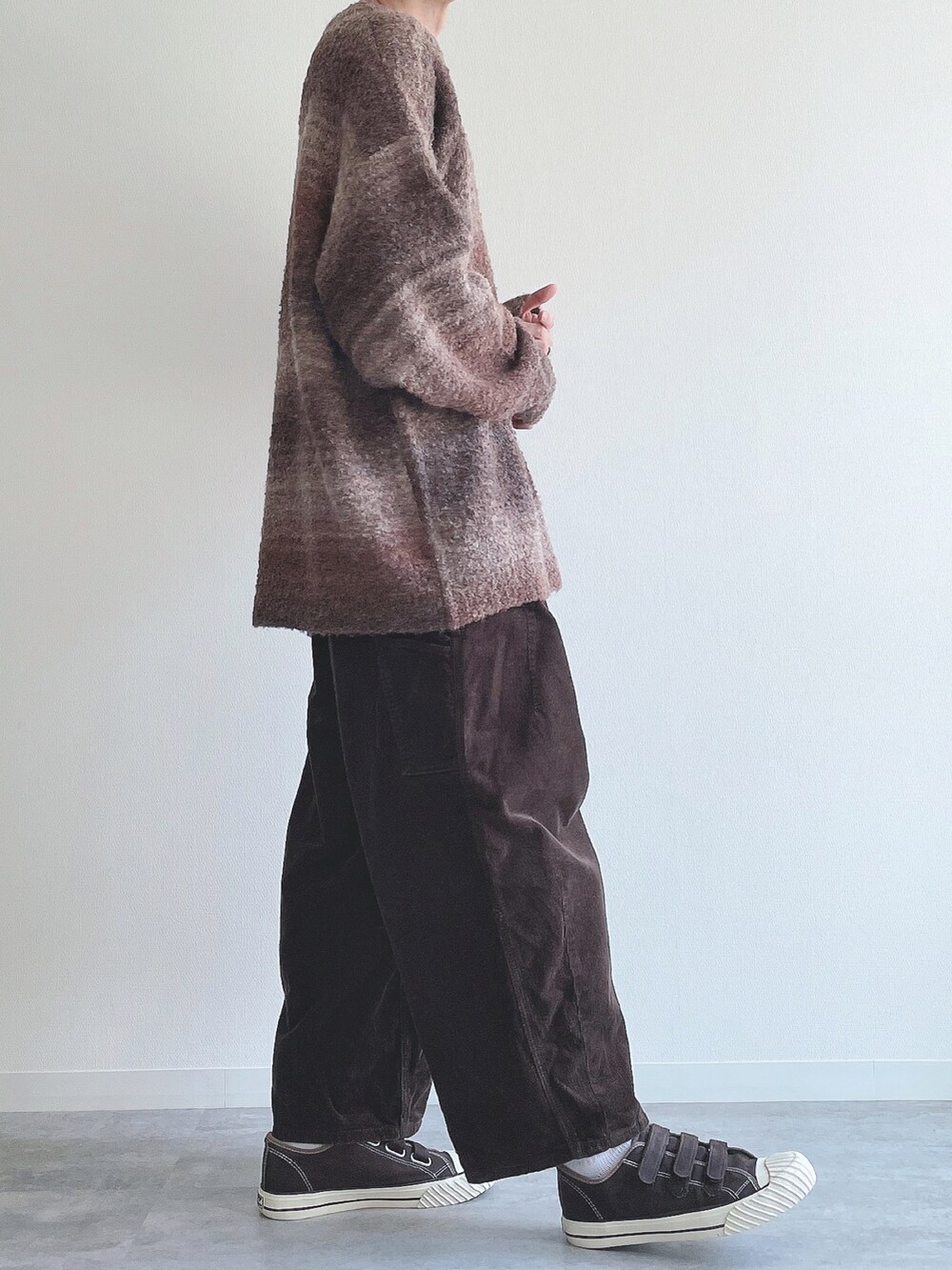 ブラウン系のニット/セーター、ブラウン系のその他パンツ、ブラウン系のスニーカーを着用したメンズの冬コーディネートの2枚目の写真