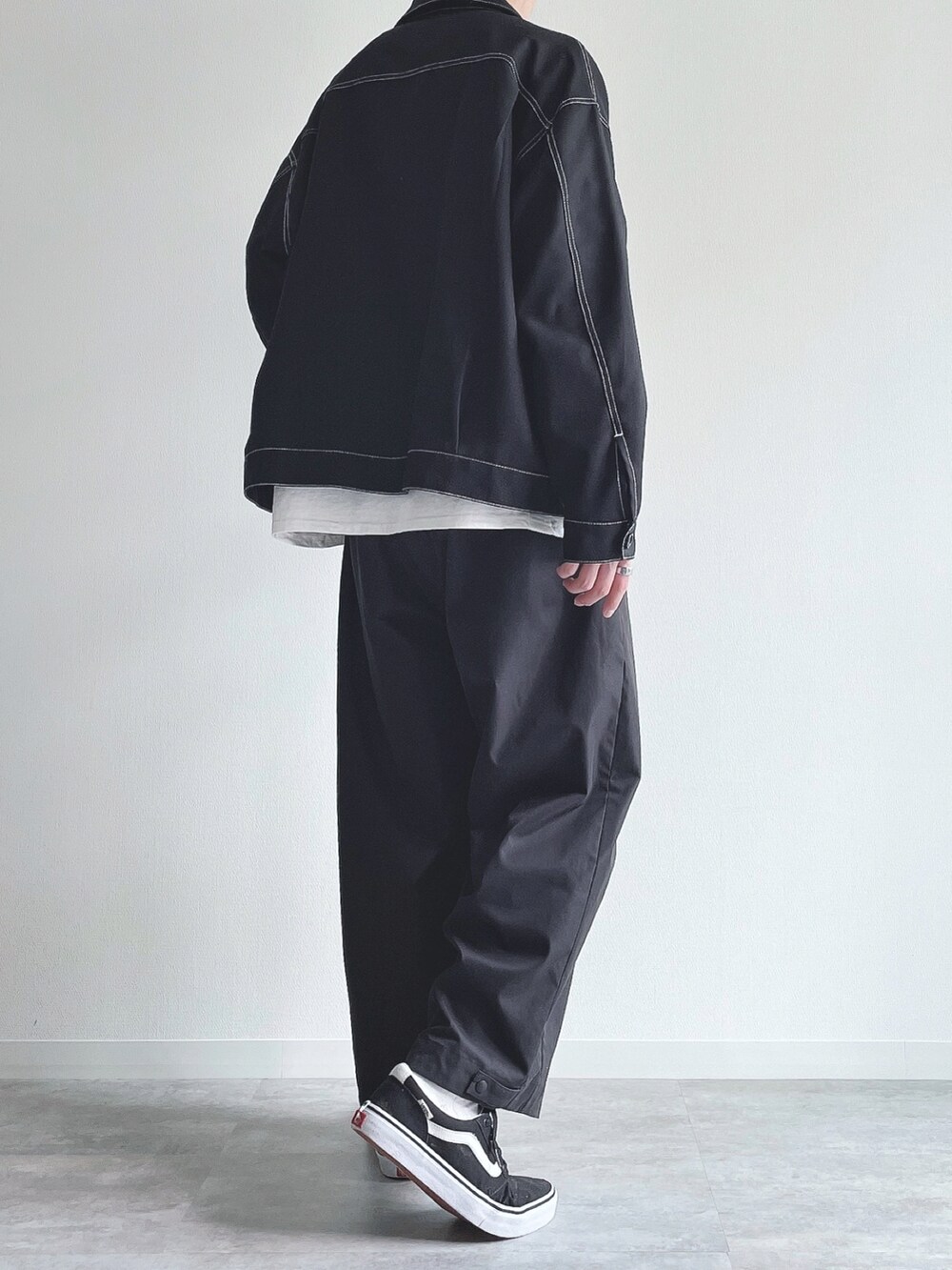 ブラック系のブルゾン、ホワイト系のTシャツ/カットソー、ブラック系のパンツを着用したメンズの春コーディネートの4枚目の写真