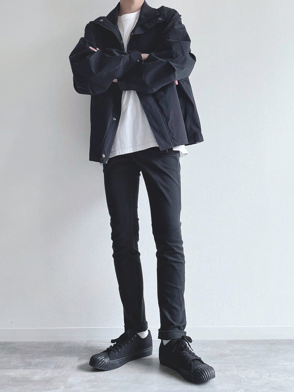 ブラック系のブルゾン、ホワイト系のTシャツ/カットソー、ブラック系のパンツを着用したメンズの秋コーディネートの5枚目の写真