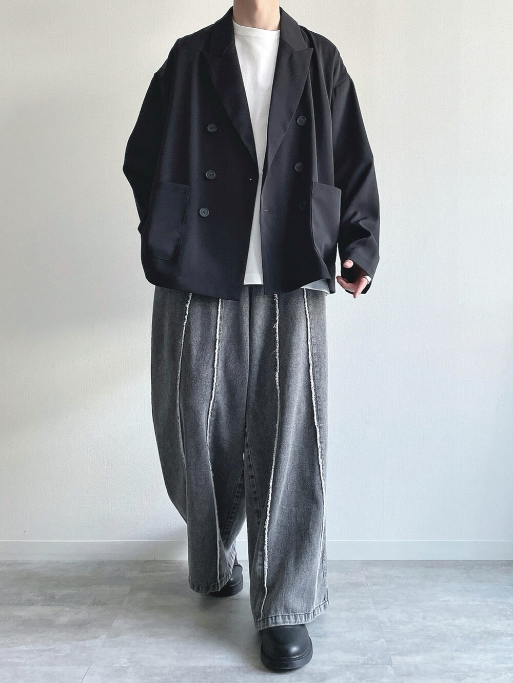 ブラック系のセットアップ、ホワイト系のTシャツ/カットソー、グレー系のデニムパンツを着用したメンズの春コーディネートの2枚目の写真