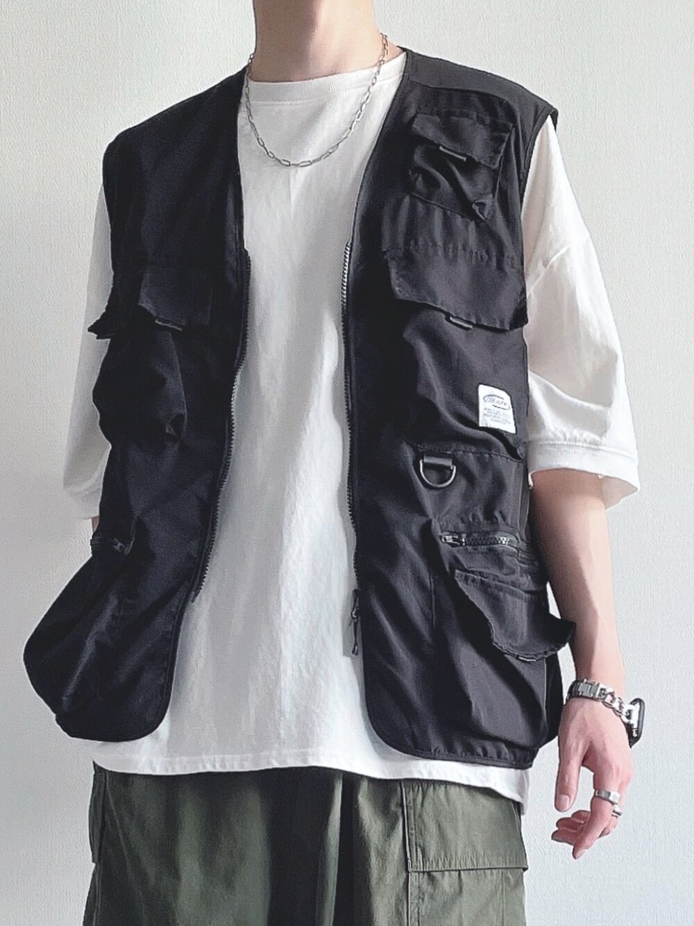 ブラック系のベスト、ホワイト系のTシャツ/カットソー、グリーン系のカーゴパンツを着用したメンズの夏コーディネートの4枚目の写真