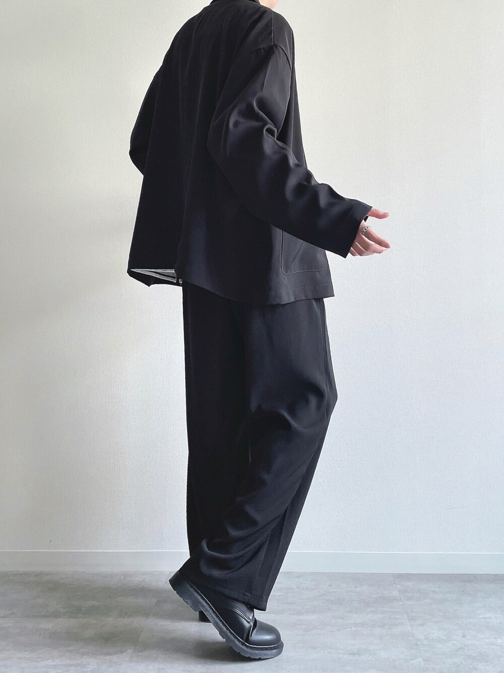 ブラック系のセットアップ、ホワイト系のTシャツ/カットソー、ブラック系のシューズを着用したメンズの春コーディネートの4枚目の写真