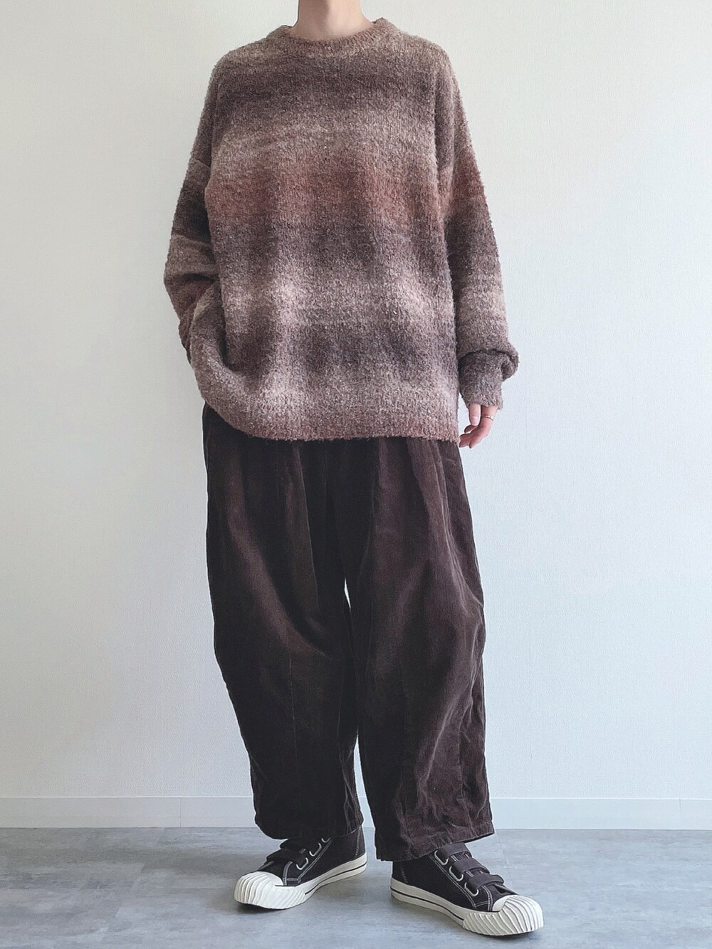 ブラウン系のニット/セーター、ブラウン系のその他パンツ、ブラウン系のスニーカーを着用したメンズの冬コーディネートの4枚目の写真