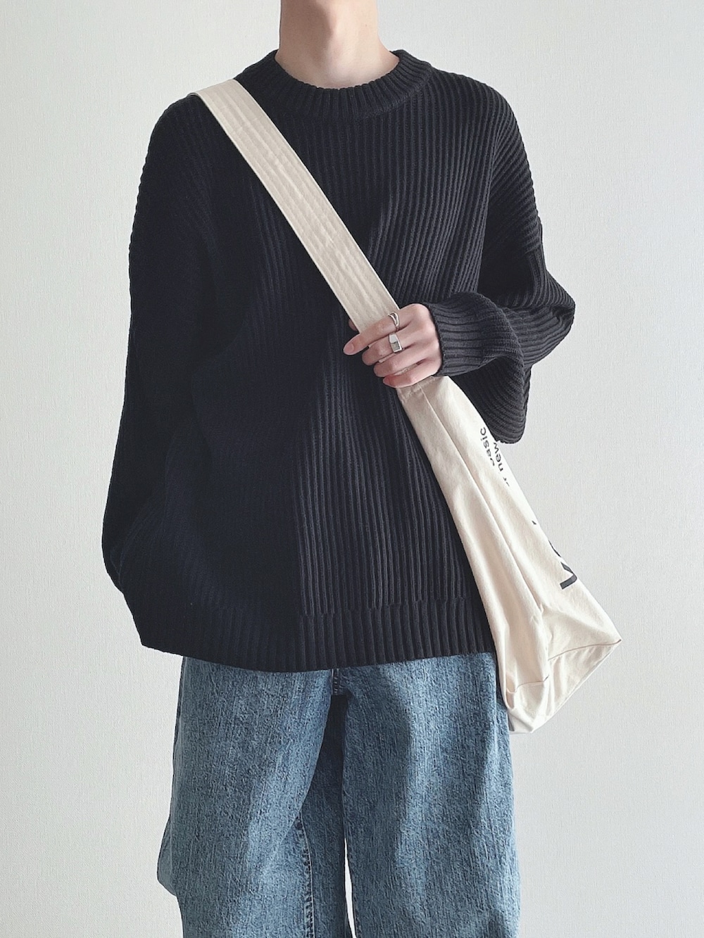 ブラック系のニット/セーター、ブルー系のパンツ、ブラック系のスニーカーを着用したメンズの冬コーディネートの4枚目の写真