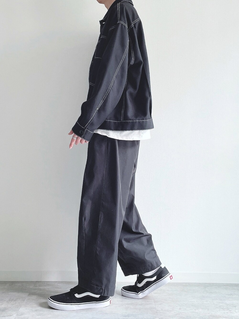 ブラック系のブルゾン、ホワイト系のTシャツ/カットソー、ブラック系のパンツを着用したメンズの春コーディネートの3枚目の写真