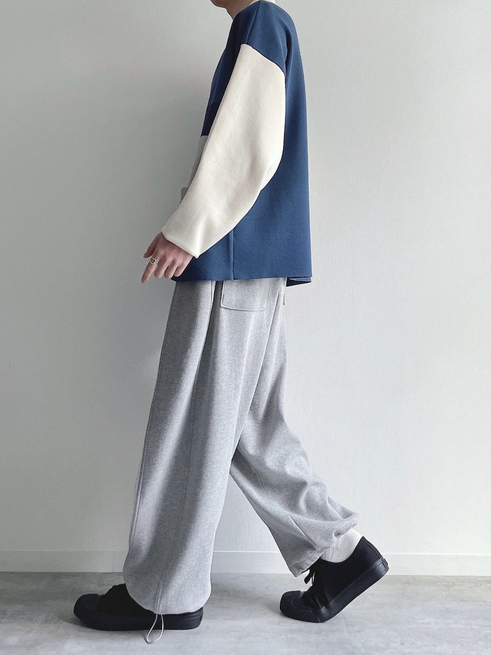 ブルー系のポロシャツ、グレー系のパンツ、ブラック系のスニーカーを着用したメンズの冬コーディネートの3枚目の写真