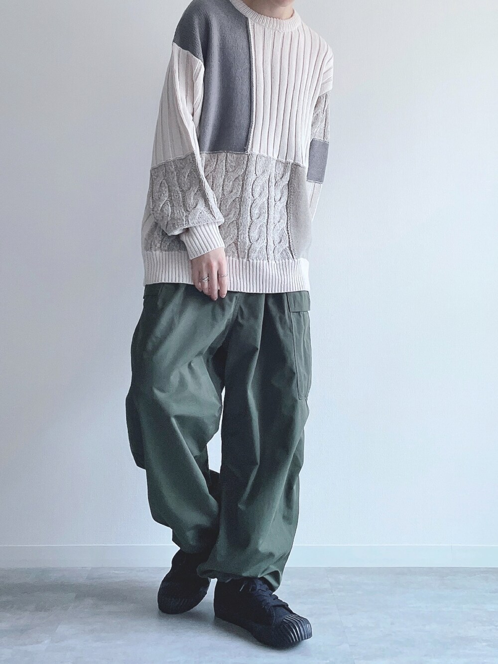 ホワイト系のニット/セーター、グリーン系のカーゴパンツ、ブラック系のスニーカーを着用したメンズの冬コーディネートの4枚目の写真