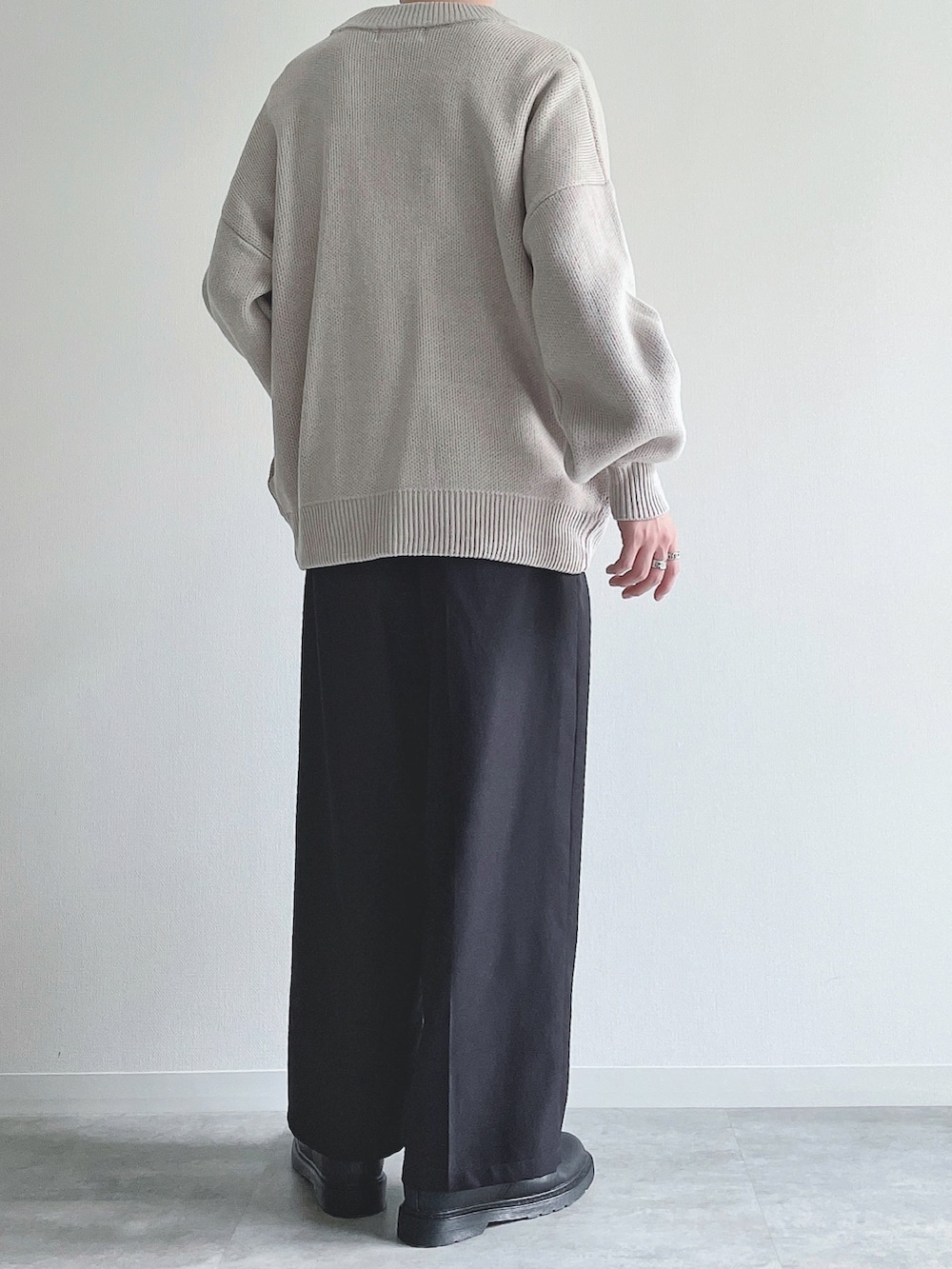 グレー系のカーディガン/ボレロ、ホワイト系のTシャツ/カットソー、ブラック系のスラックスを着用したメンズの秋コーディネートの4枚目の写真