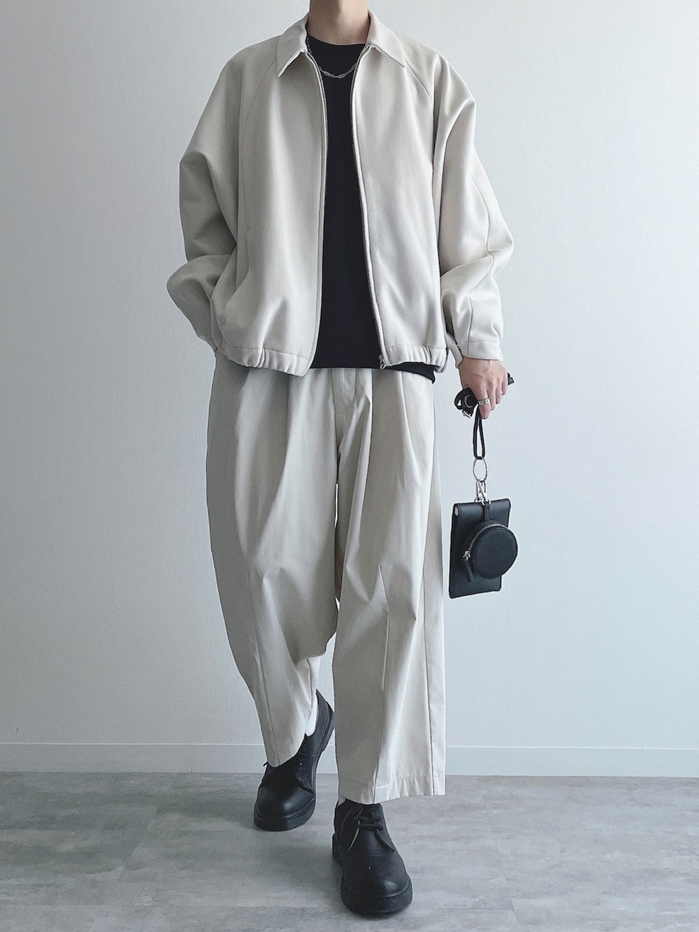 ホワイト系のブルゾン、ブラック系のトップス、ホワイト系のその他パンツを着用したメンズの秋コーディネートの4枚目の写真