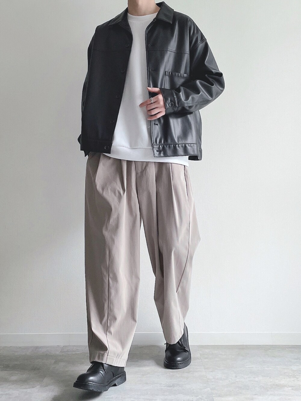 ブラック系のブルゾン、ホワイト系のトップス、ベージュ系のその他パンツを着用したメンズの冬コーディネートの5枚目の写真