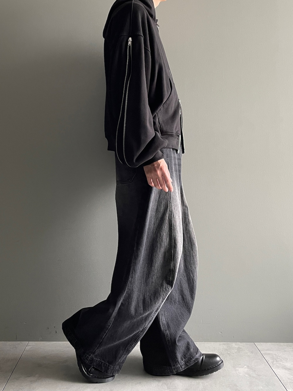 ブラック系のパーカー、ブラック系のデニムパンツ、ホワイト系のTシャツ/カットソーを着用したメンズの冬コーディネートの2枚目の写真