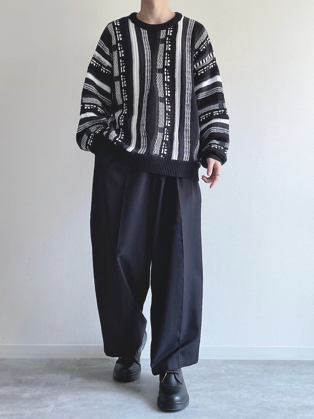 ブラック系のニット/セーター、ブラック系のスラックス、ブラック系のシューズを着用したメンズの冬コーディネートの2枚目の写真