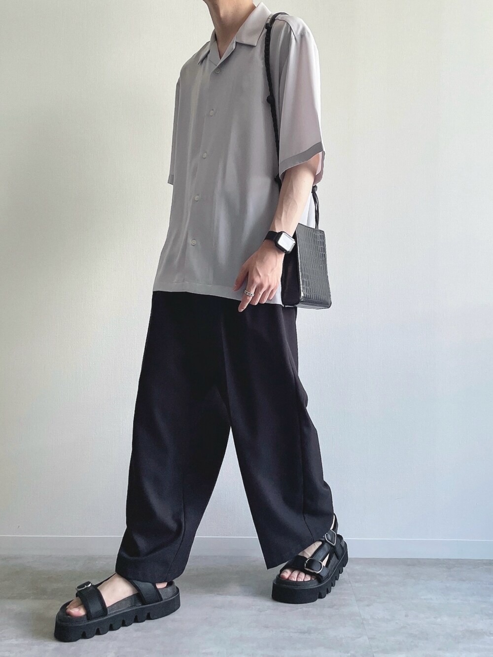 グレー系のトップス、ホワイト系のタンクトップ、ブラック系のスラックスを着用したメンズの夏コーディネートの4枚目の写真