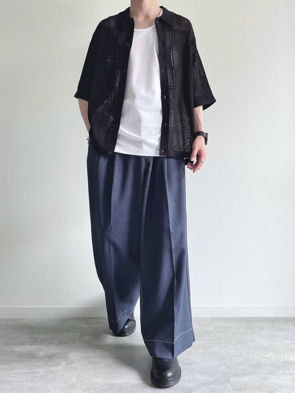 ブラック系のトップス、ホワイト系のタンクトップ、ブルー系のデニムパンツを着用したメンズの夏コーディネートの2枚目の写真